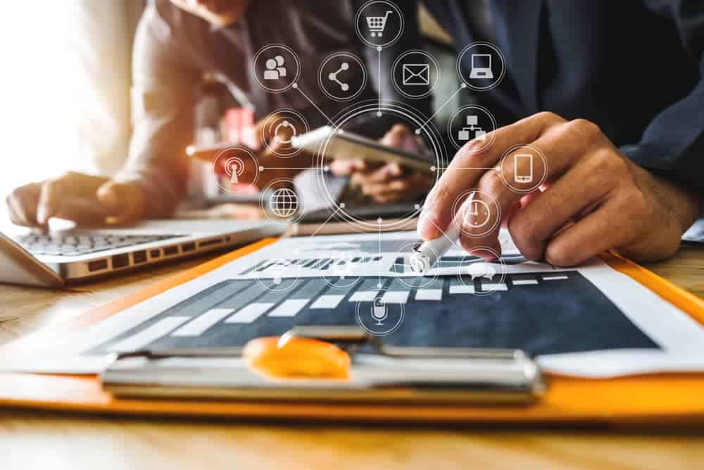 Hommes consultant des rapports sur une tablette et un ordinateur