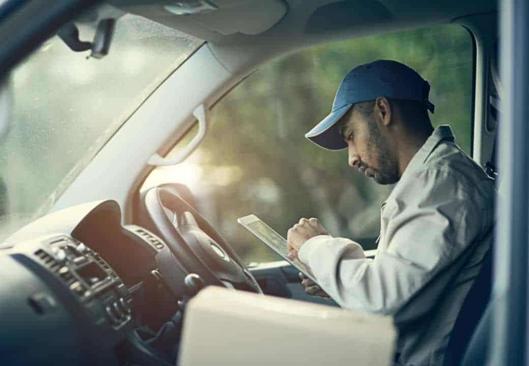 livreur avec un colis dans sa camionnette