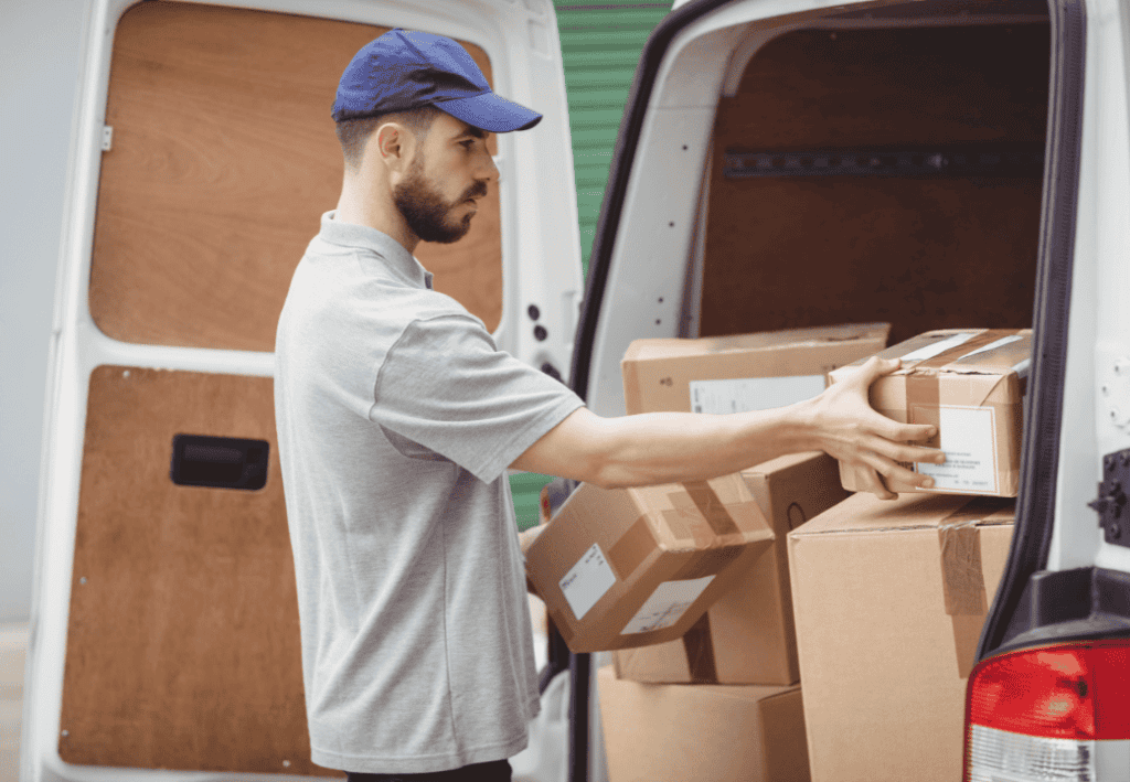 Delivery man holding a parcel next to his truck