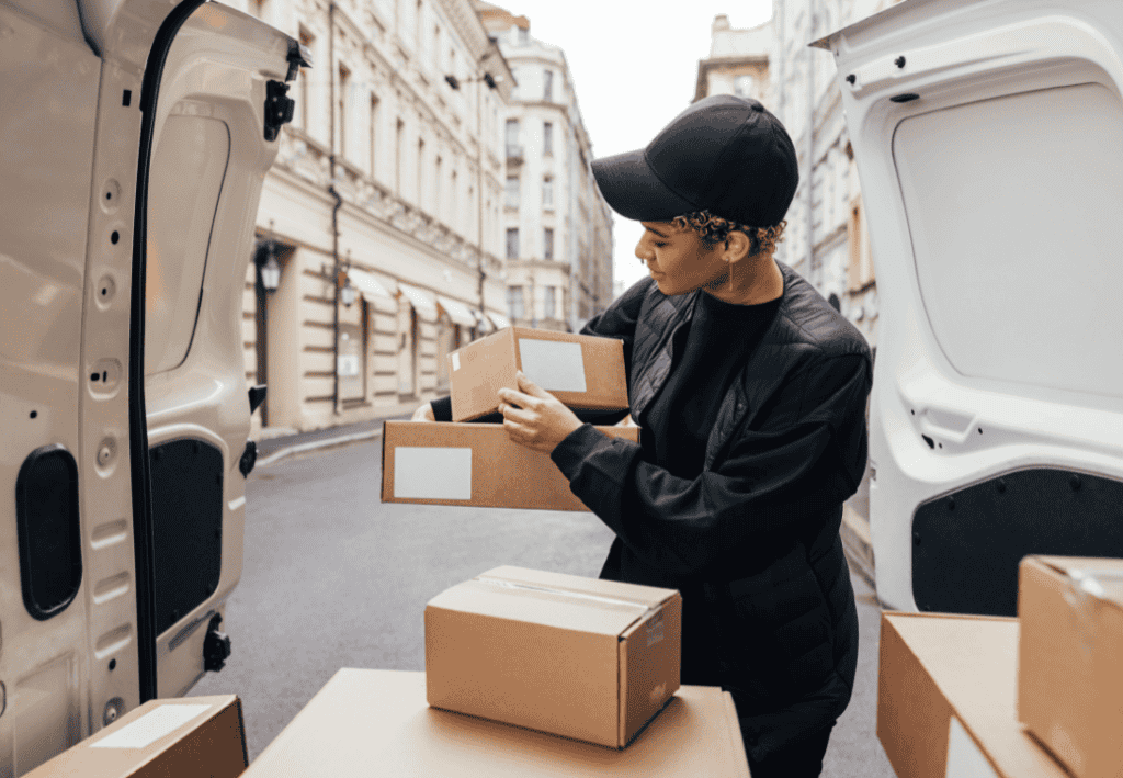 Woman delivery driver taking a parcel in her truck